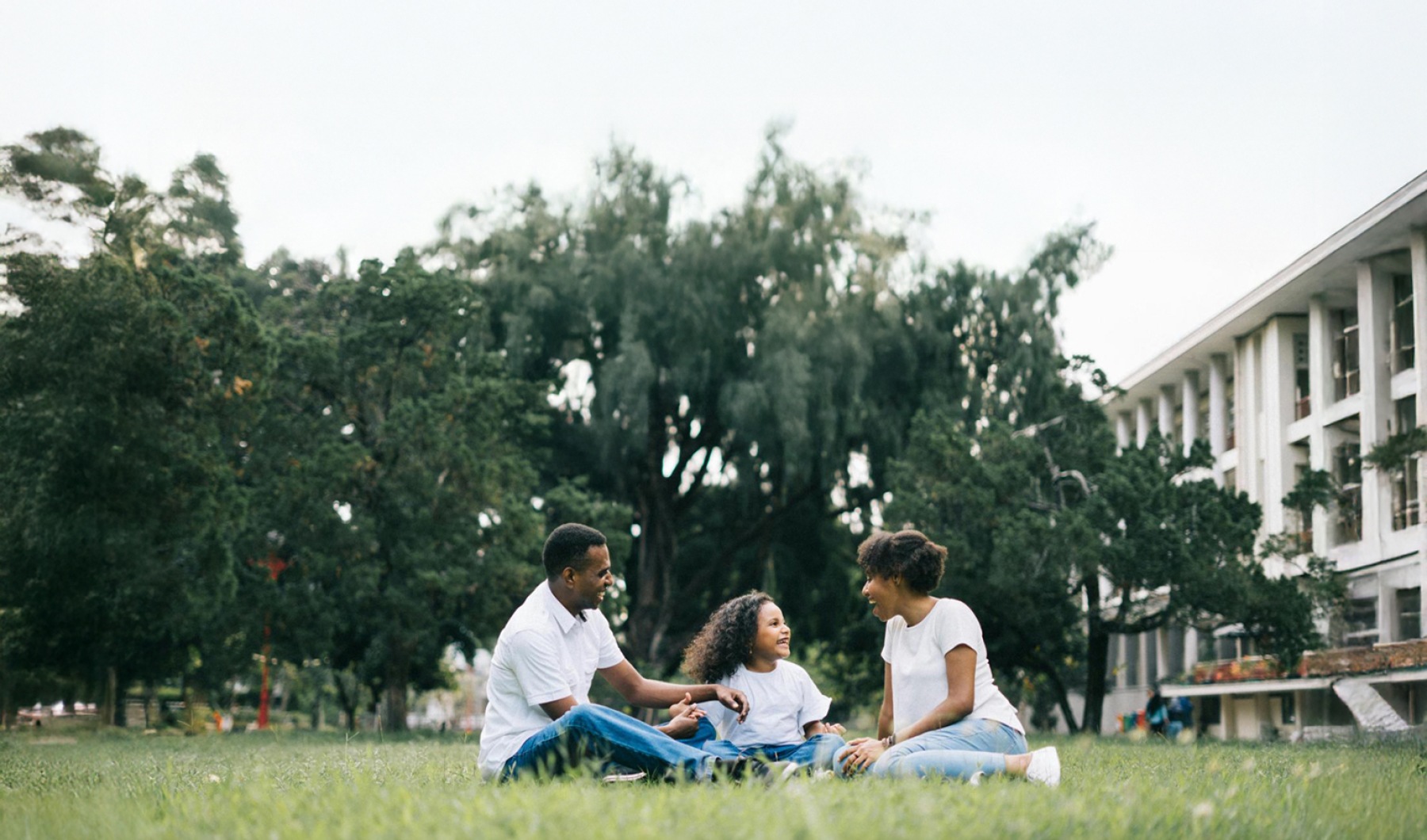 Take Root. Stretch. Flourish a family sitting on the grass